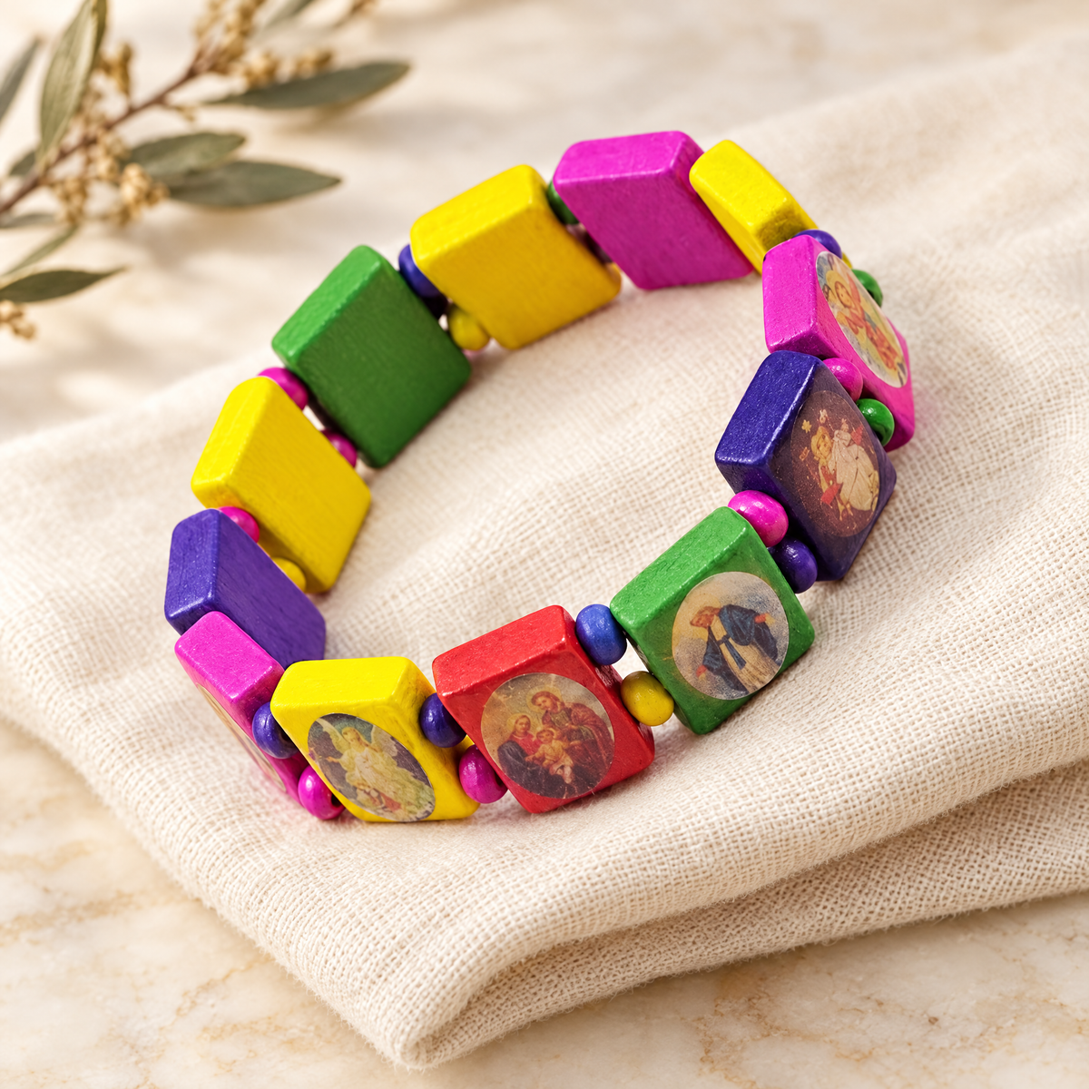 Colorful wooden saints rosary bracelet on ivory linen